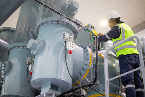 Schilderij op canvas Technician performs maintenance on large insulated gas switchgear in substation