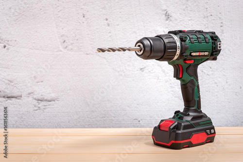 Screwdriver drill on a wooden background