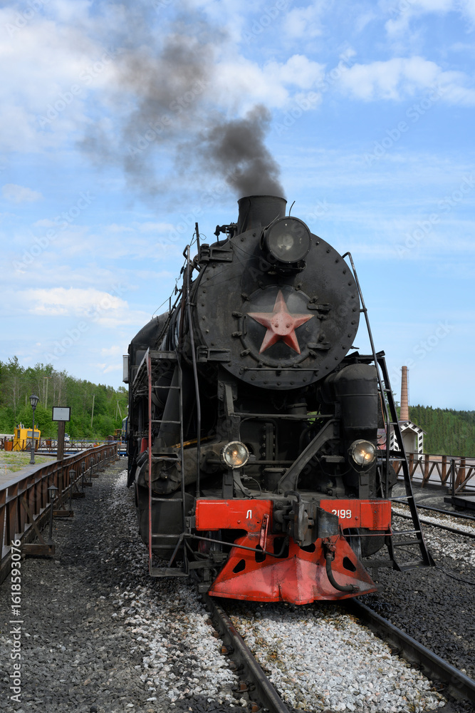 Fototapeta premium Retro steam locomotive of the mid-20th century with a smoking pipe in Karelia
