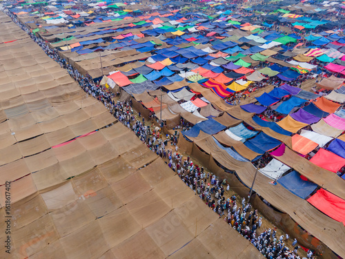 Aerial view of a sprawling tent city, a vibrant tapestry of colorful fabrics stretched over bustling pathways teeming with people, Dhaka, Dhaka Division, Bangladesh.