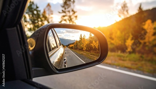 Autumn road trip: Driving through colorful forest with sunset in mi...