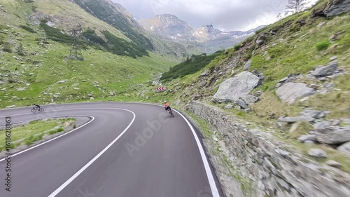 Cyclist rides along a winding mountain road with stunning views. Perfect for travel, sports, or adventure themes. High-quality footage.