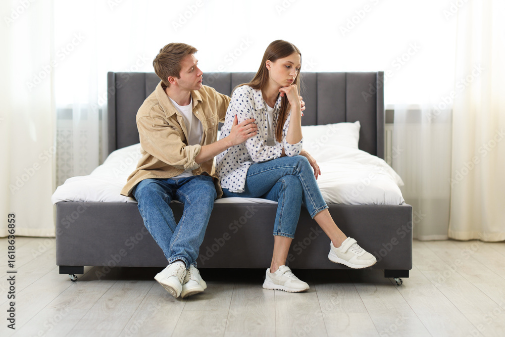 Man apologizing to his offended girlfriend on bed at home Man apologizing to his offended girlfriend on bed at home