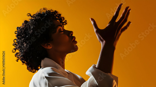Woman In Profile Pose With Hands Raised Against Vivid Yellow Background