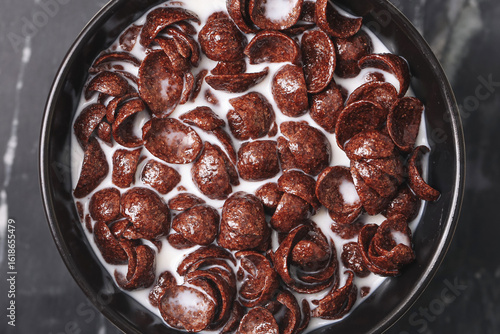 Wallpaper Mural Chocolate cereal with milk in bowl closeup. Top view of crunchy cocoa cornflakes breakfast. Sweet chocolate flakes floating in fresh milk. Tasty morning meal concept for kids and family at home. Torontodigital.ca