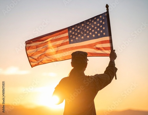 Silhouette of a soldier holding the American flag high against a bright, golden sunset.