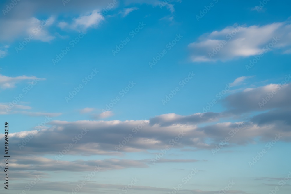 Obraz premium Wispy clouds on a bright blue sky white grey