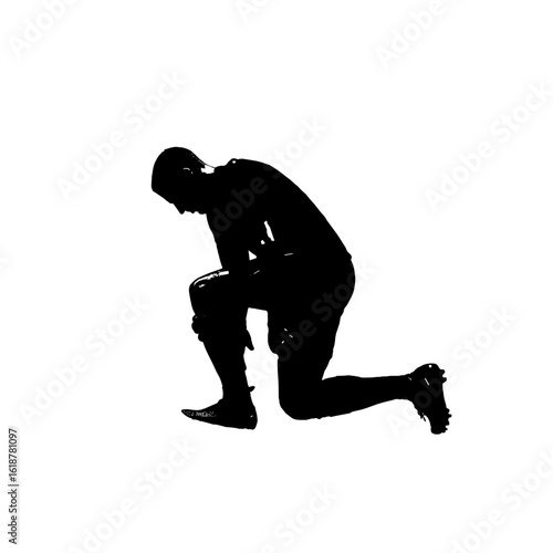 Silhouette of a football player kneeling down.