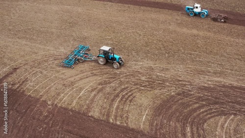 A tractor with a grain seeder is working in the field