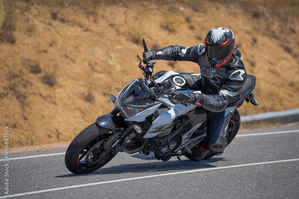 Obraz premium Motorcyclist leaning into curve on sport bike