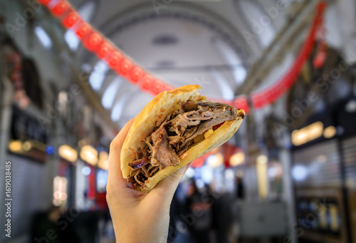 Photography A woman holds a donner kebab sandwich inside the Grand Bazaar, Istanbul, Turkey