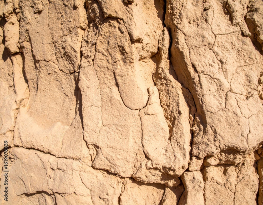 Obraz premium Sandy Beige Rock Texture with Cracks and Weathered Details in Arid Climate