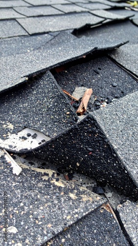 Damaged Roof Shingles with Missing Pieces Revealing the Underlayment and Weathering Marks
