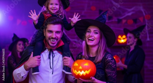 Photo of a happy family dressed in halloween costumes are celebrating the holiday with a carved pumpkin and having fun at a party