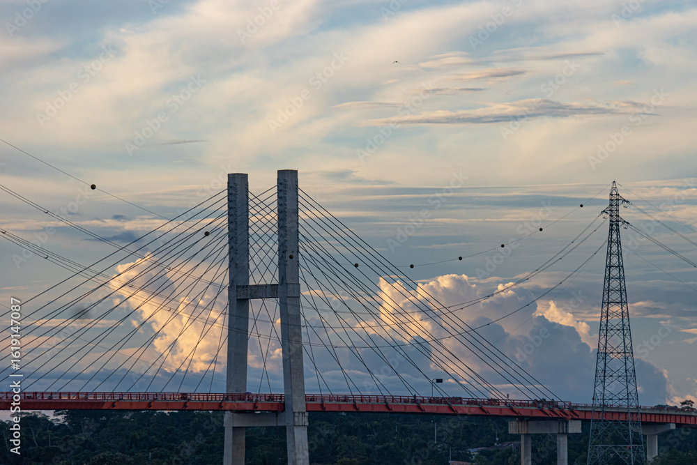 Fototapeta premium Puente atirantado sobre cielo azul con nubes al atardecer, paisaje vistoso 