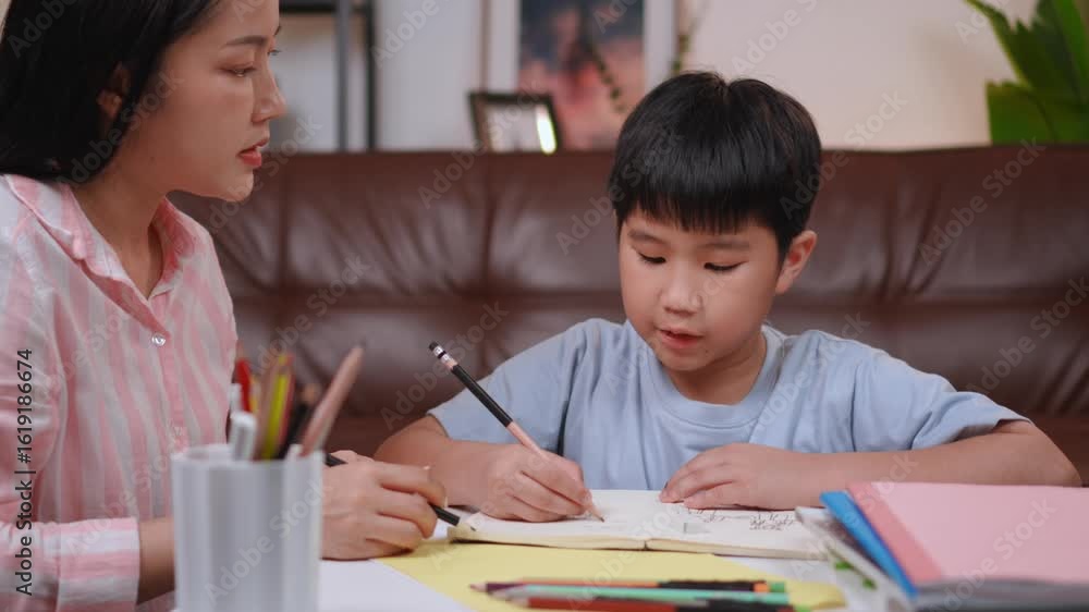 Asian mother teaching her son homework in the living room Asian mother teaching her son homework in the living room