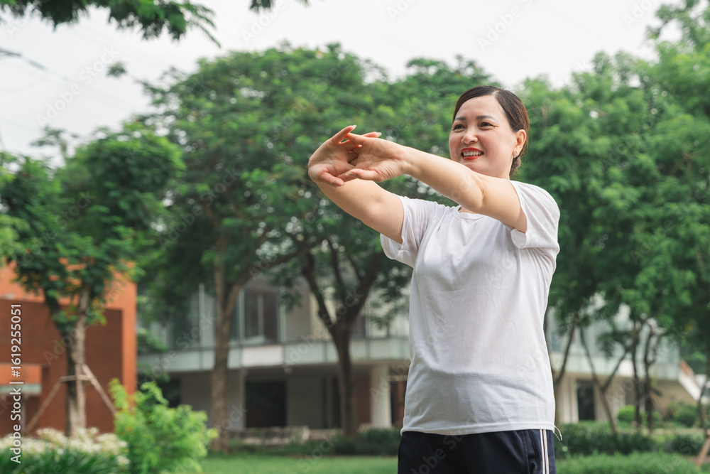Obraz premium Mature woman doing stretching exercises in park Healthy lifestyle concept Copy space