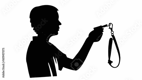 Silhouette of a person holding a whistle with a lanyard in their hand against a white background view