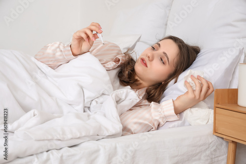 Ill young woman with thermo...