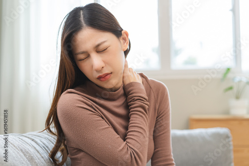 Free Download Pain body muscles stiff problem, suffer asian young woman, girl painful with back, holding neck ache from work hand holding massaging rubbing shoulder hurt, sore sitting on couch at home. Health care - GFXLoad