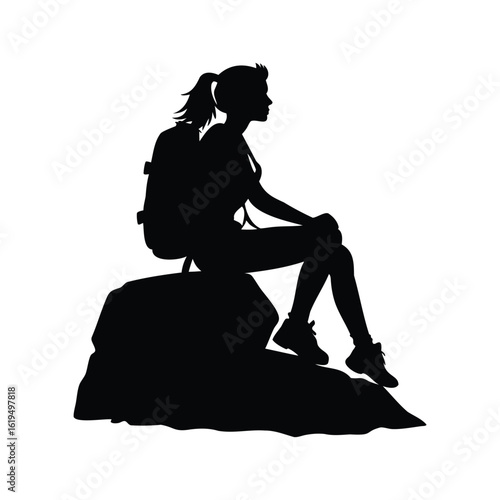 Silhouette of a female hiker resting on a rock in nature