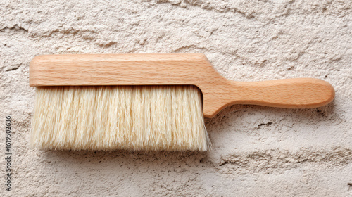 Wooden brush with natural bristle on textured wall for cleaning