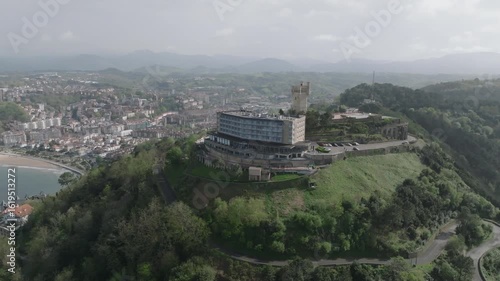 Wallpaper Mural Drone aerial shot of San Sebastián (Spain) with La Concha Bay, the city skyline, and Monte Igueldo’s iconic tower. A scenic coastal view from above, perfect for travel and tourism themes. Torontodigital.ca
