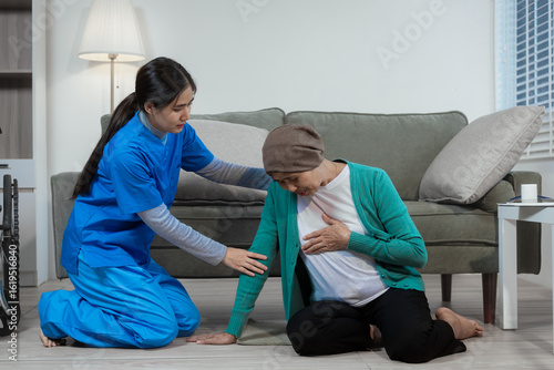 Valokuvatapetti An Asian nurse rushed to the aid of an elderly female cancer patient who had fallen near her wheelchair
