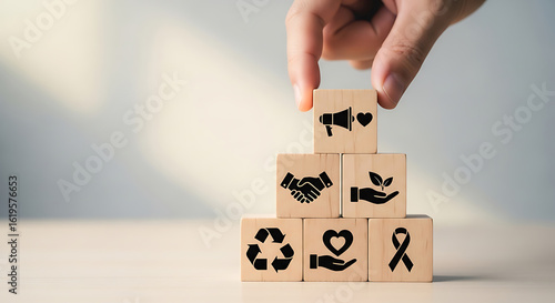 Hand arranging wooden blocks symbolizing core values and community outreach