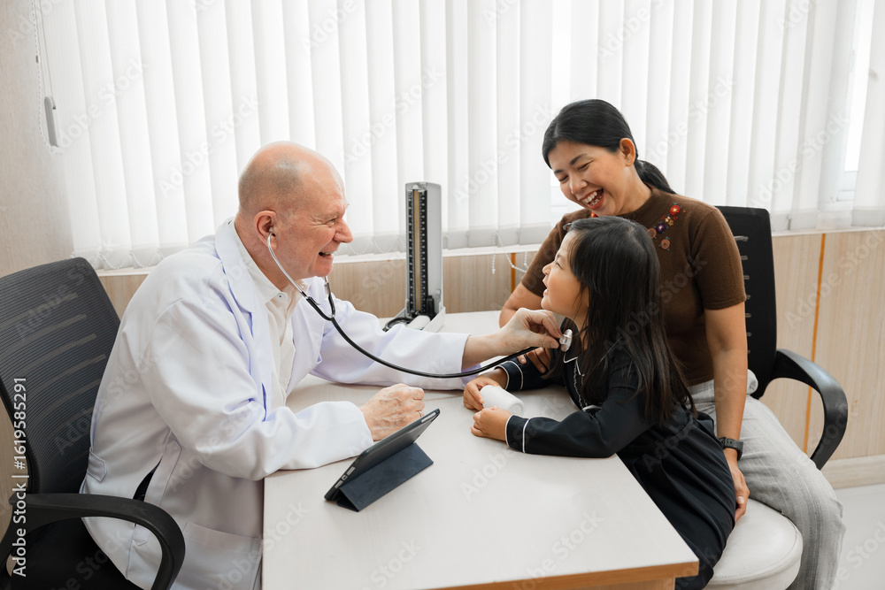 Obraz premium Caucasian Doctor use stethoscope take care Asia kid girl with assistant at hospital 