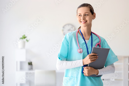 Female medical intern with notebook in clinic