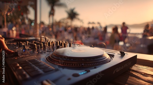 DJ turntable equipment set up outdoors at sunset with people in background