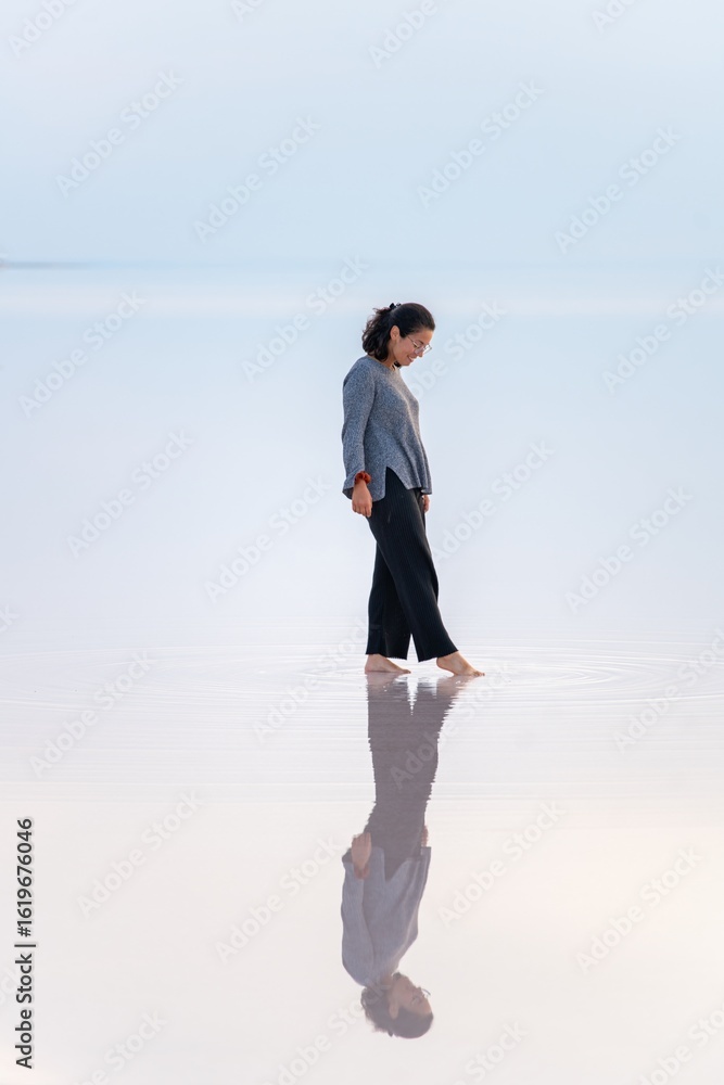 Woman walking on the reflecting surface of Tuz Lake in Turkey Woman walking on the reflecting surface of Tuz Lake in Turkey