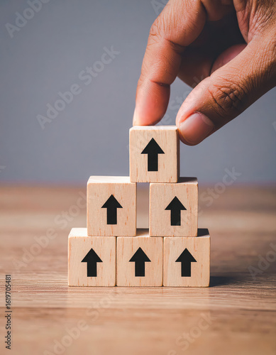 Close up hand and stack of wood block cube on the table.