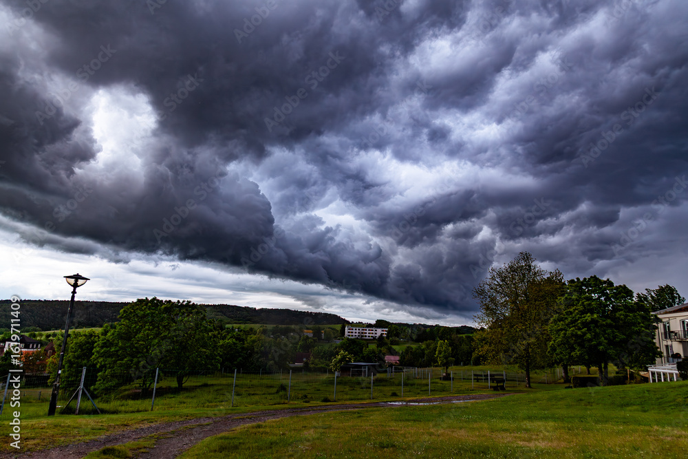 Obraz premium storm clouds wall cloud over a rural town with fields in the background