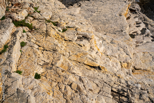 Warm-colored limestone rock with deep cracks and textures near the edge of the Adriatic Sea in Cape Kamenjak. A beautiful example of coastal erosion and geology