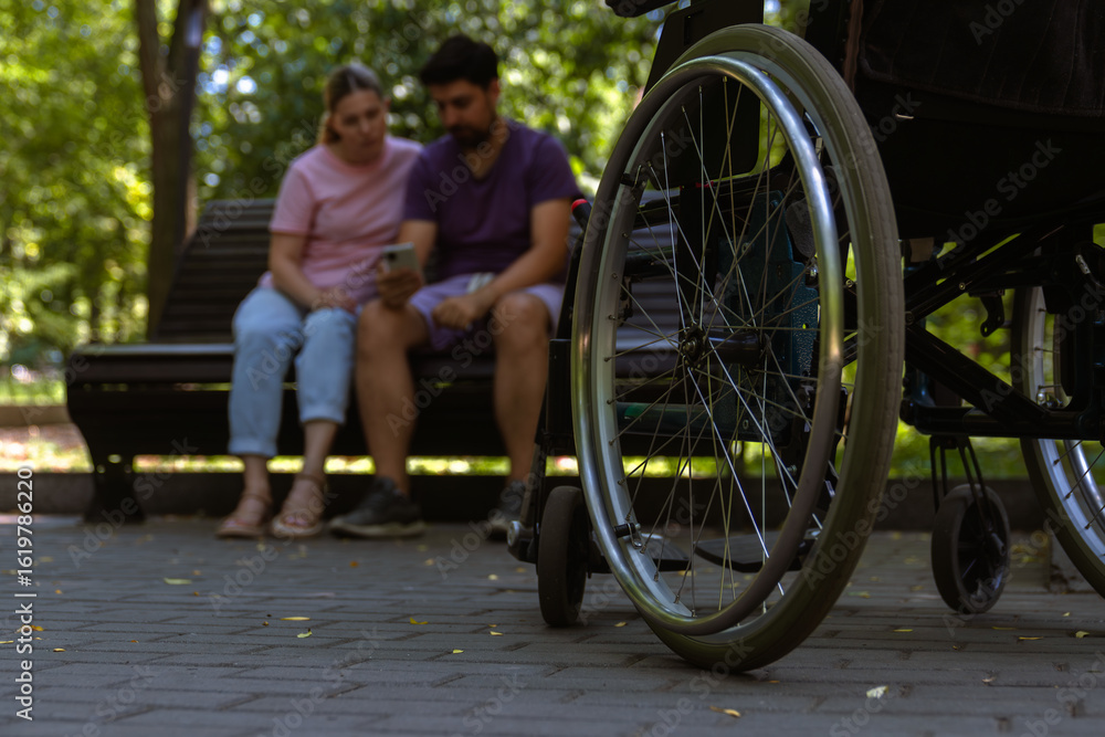 Fototapeta premium Wheelchair Focused in Urban Park Setting with Couple