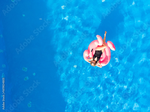 Summer background. Aerial drone view of woman in pool in hotel. Summer holidays, enjoying summer vacations.