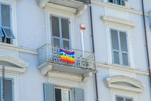 Rainbow Pace Flag. International Peace Day. Rainbow flag on the balcony of an old house. Windows with shutters. Facade of the building. Italy La Spezia