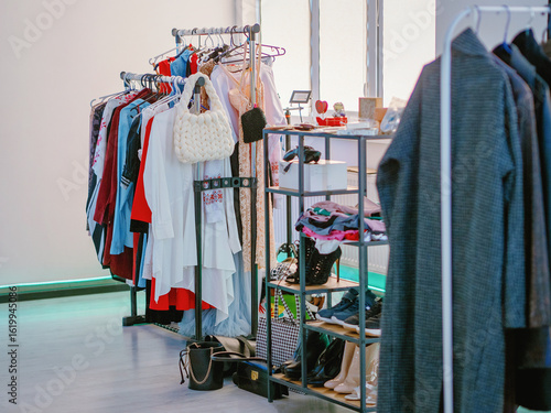 Fotografía Clothing store with clothes shoes and bags on hanger stands
