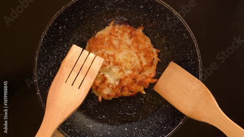wooden spatula flips hash browns on hot pan. top view. High quality 4k footage