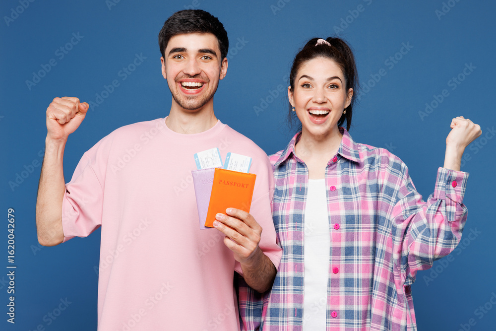 Traveler winner couple two man woman wear casual clothes hold passport ticket isolated on plain blue background. Tourist travel abroad in free spare time rest getaway. Air flight trip journey concept. Traveler winner couple two man woman wear casual clothes hold passport ticket isolated on plain blue background. Tourist travel abroad in free spare time rest getaway. Air flight trip journey concept.