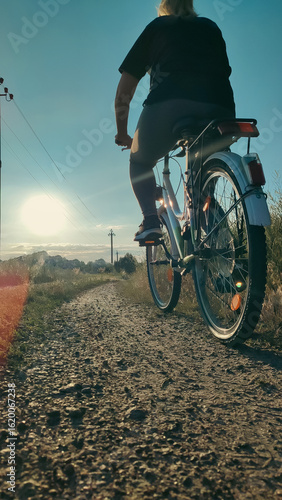 Wallpaper Mural Woman riding cruiser bike riding in remote area on sunset. Back view. Cyclist girl biker enjoys freedom, healthy lifestyle, sport activity. Active summer holidays. Torontodigital.ca