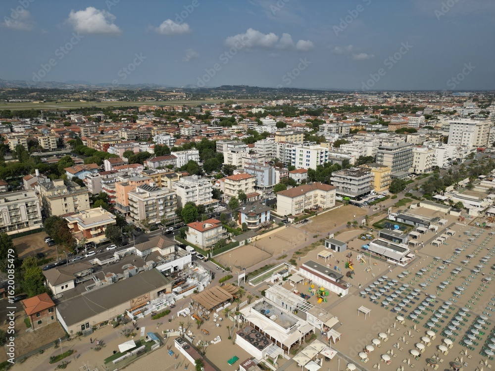 Fototapeta premium Coastal Urban Vista: An expansive aerial view captures a vibrant seaside town, showcasing an appealing fusion of urban development and natural beauty, Rimini, Italy