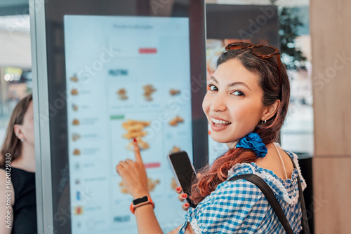 Konstfotografi Customer girl ordering food at a fast food restaurant, interacting with a self s