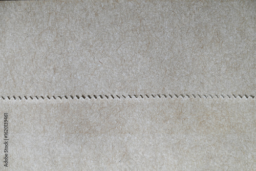 Wall Mural Perforated kraft paper texture background with zigzag seam