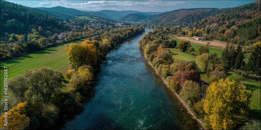 Aerial view of the Marvelde River in Germany, surrounded by forest and fields, with distant mountains in autumn colors. A small town is visible on one side along the riverbank. Aerial view of the Marvelde River in Germany, surrounded by forest and fields, with distant mountains in autumn colors. A small town is visible on one side along the riverbank.