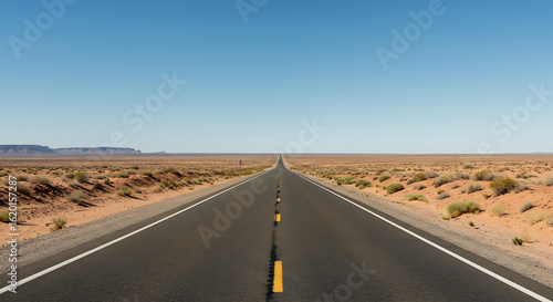 Long Asphalt Road Through Desert Landscape Under Clear Sky.