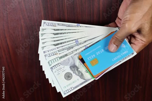 Stop motion of credit card hand and 100 dollar us bill.