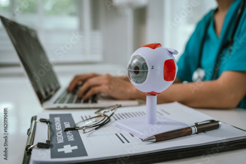 Tableau sur toile A physician performing an eye examination using an anatomical eye model and providing professional consultation and treatment in a medical setting to ensure proper diagnosis and vision care